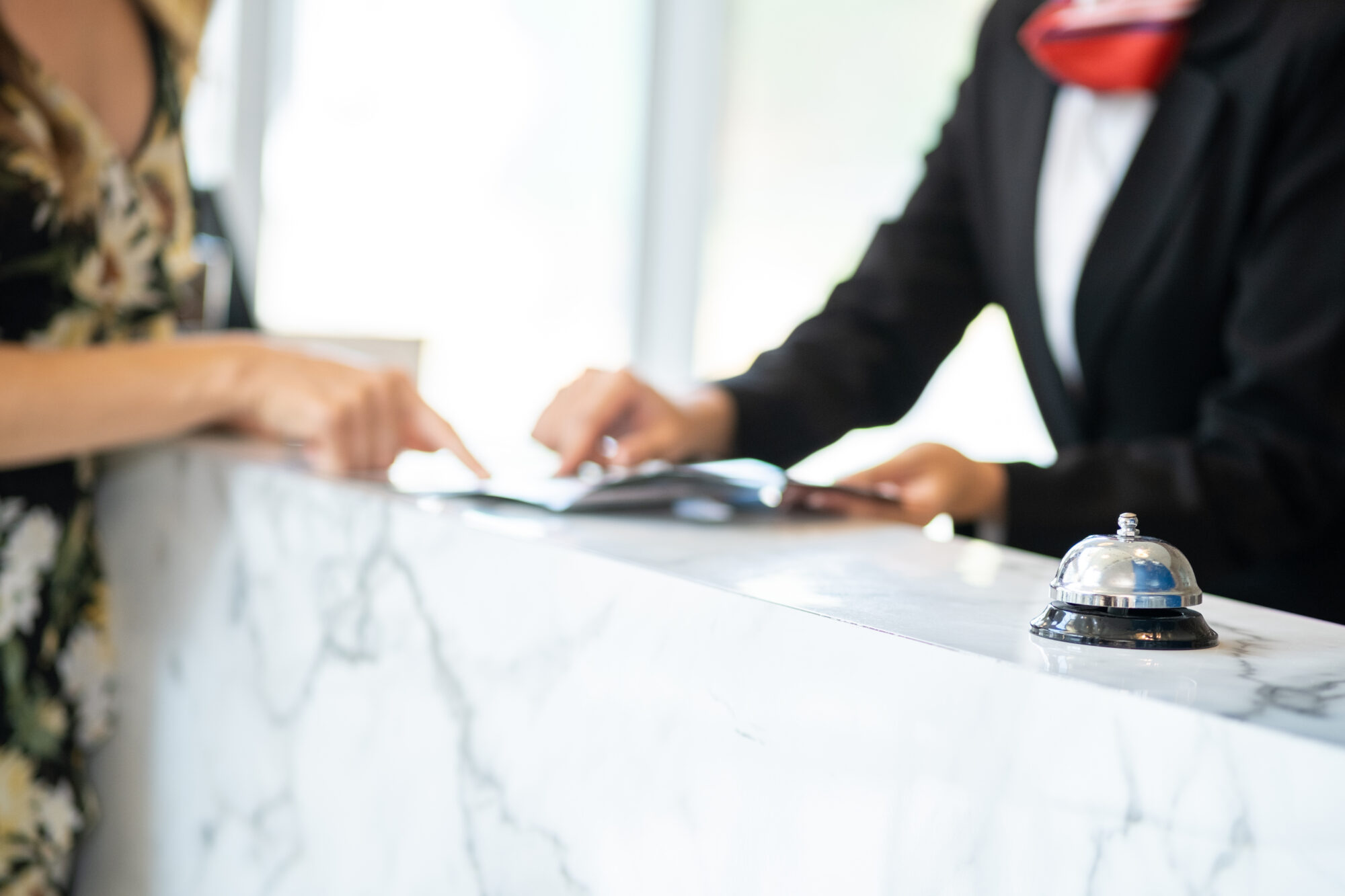 A hotel concierge explaining information to a guest at the counter